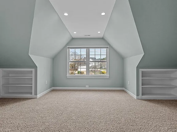 Bonus room with a dormered ceiling, recessed lighting, built-in shelving, and a central window