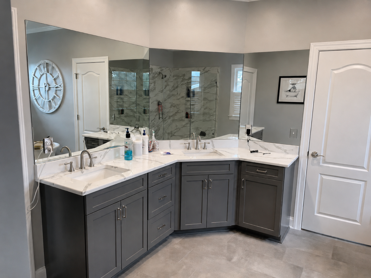 Wraparound gray double vanity with marble-look counters and full-width mirrors