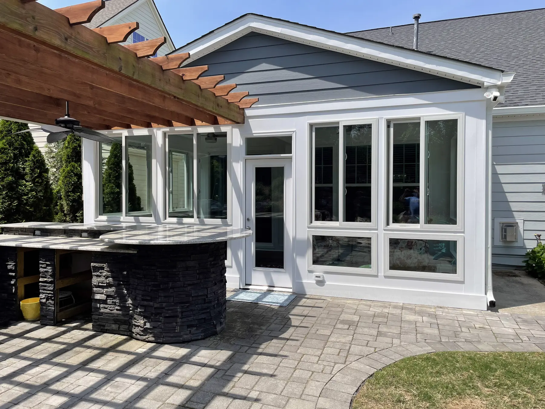 Backyard view of the finished addition and adjacent pergola