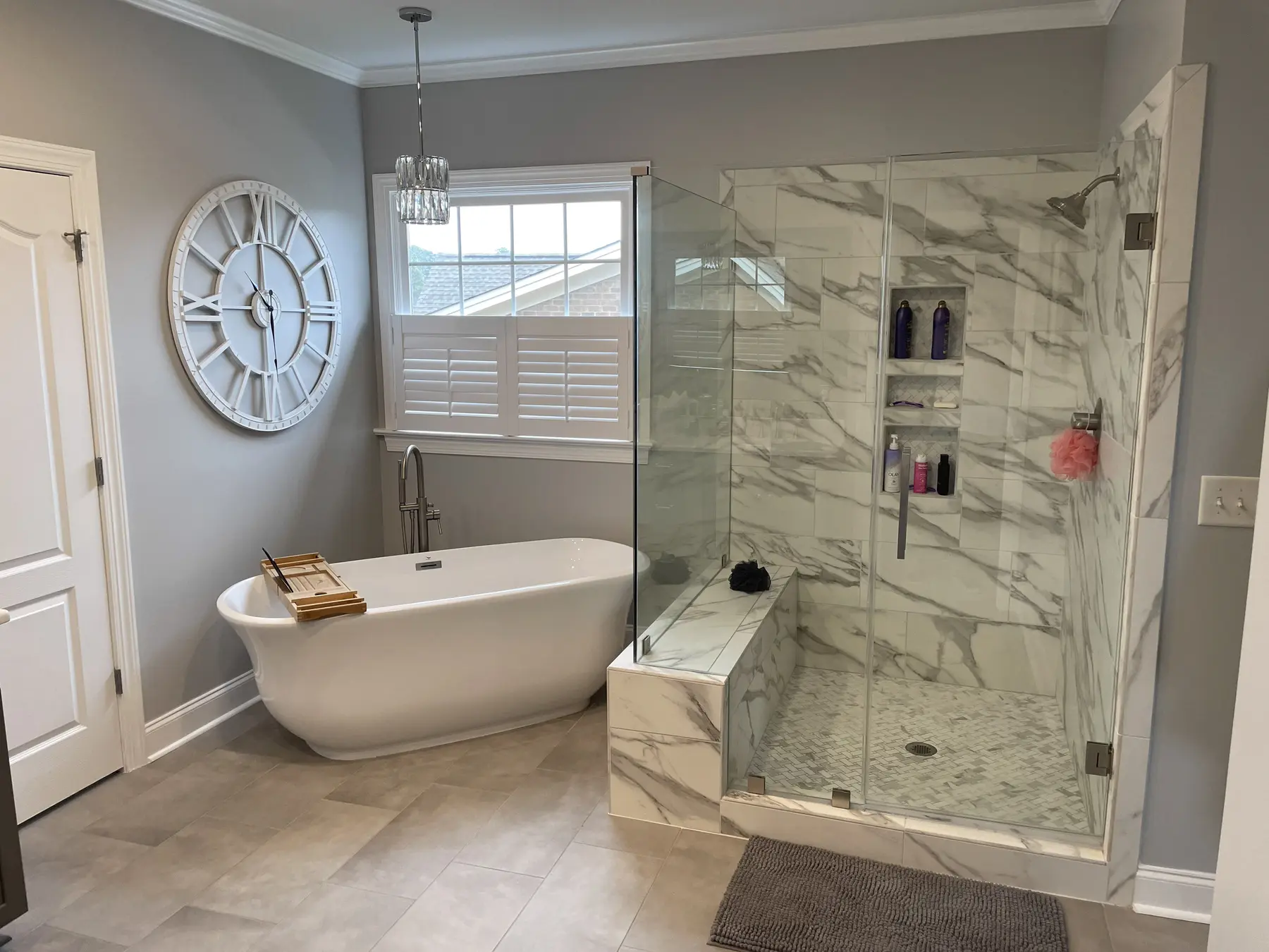 Renovated primary bathroom with freestanding tub and glass corner shower
