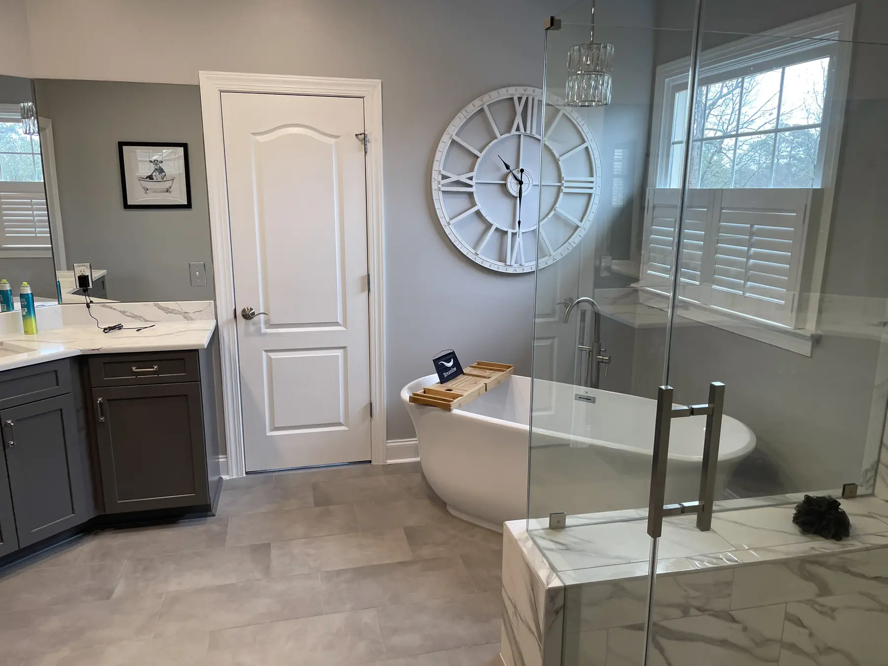 Freestanding soaking tub beside the glass corner shower