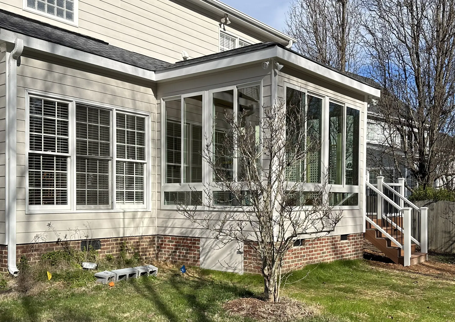 Side view of the sunroom's tall windows and brick foundation