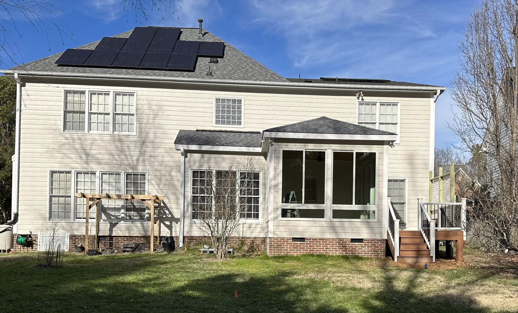 Wide backyard view showing the new sunroom in context