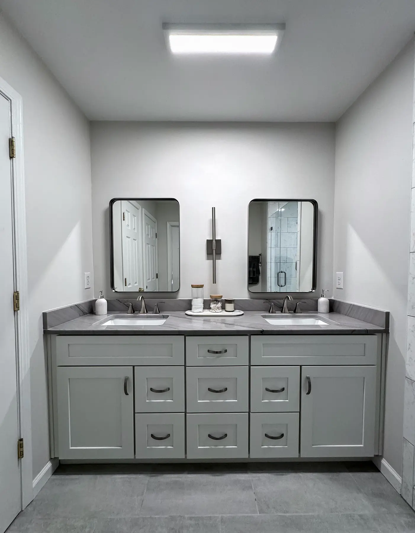 Double vanity with gray cabinetry and two framed mirrors