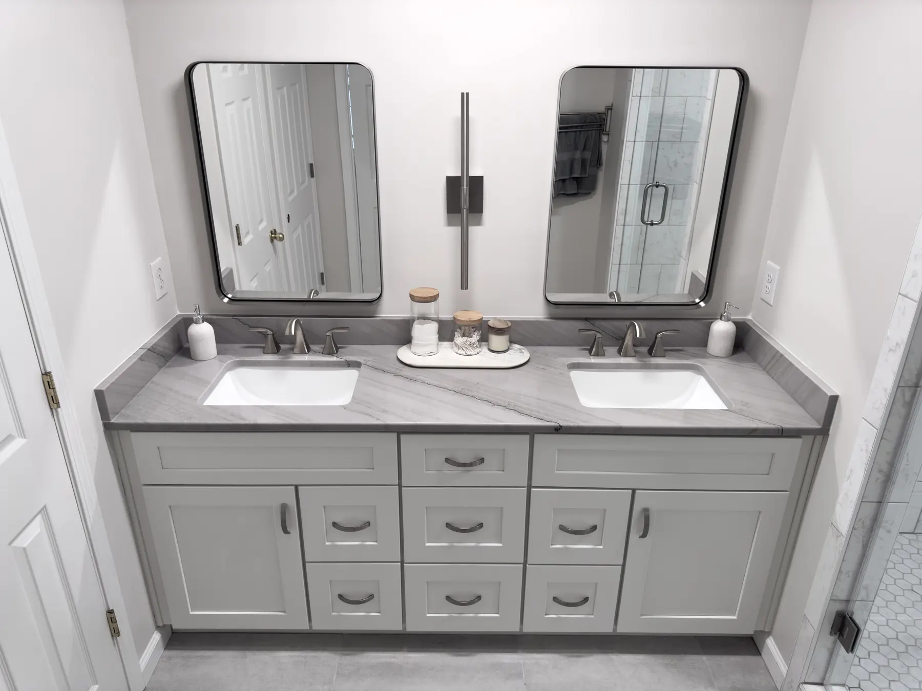 Wide view of the gray double vanity and mirrored wall