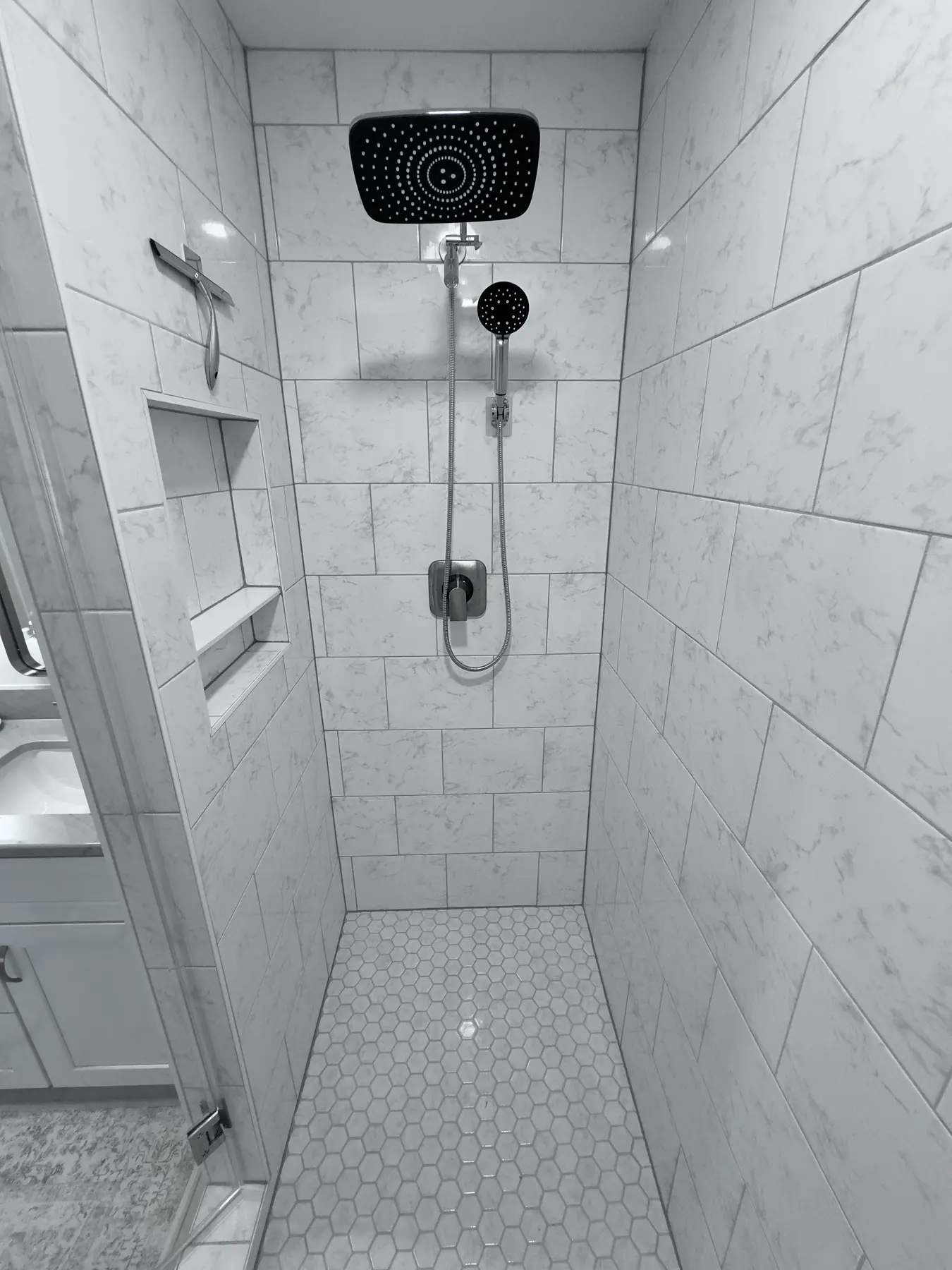 Walk-in shower with rain head and built-in wall niches