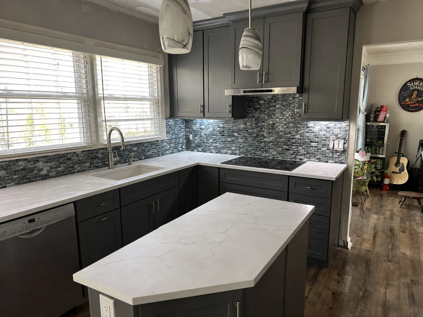 Gray kitchen with wraparound cabinetry and a window over the sink