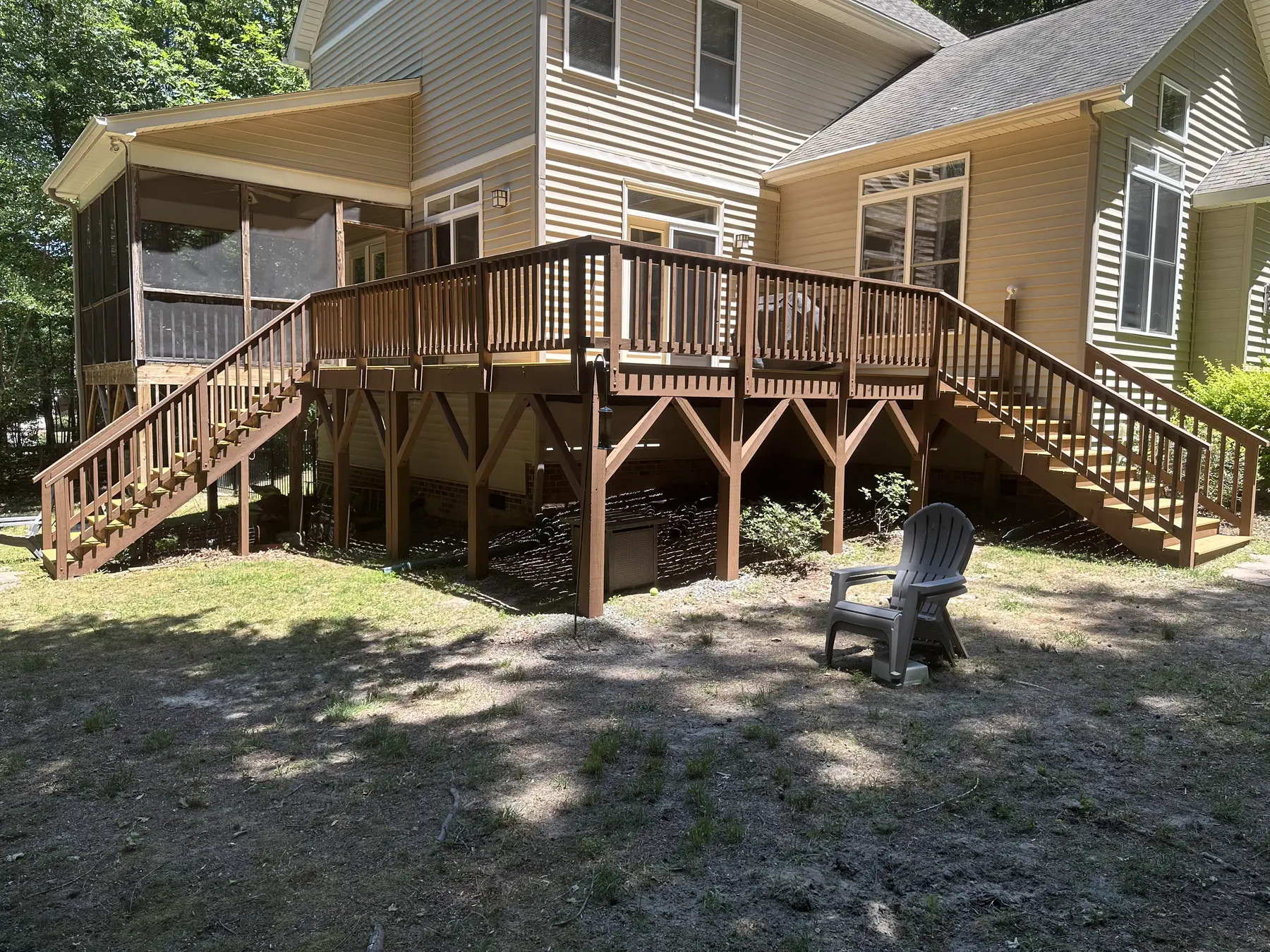 Large elevated backyard deck connecting two rear doors