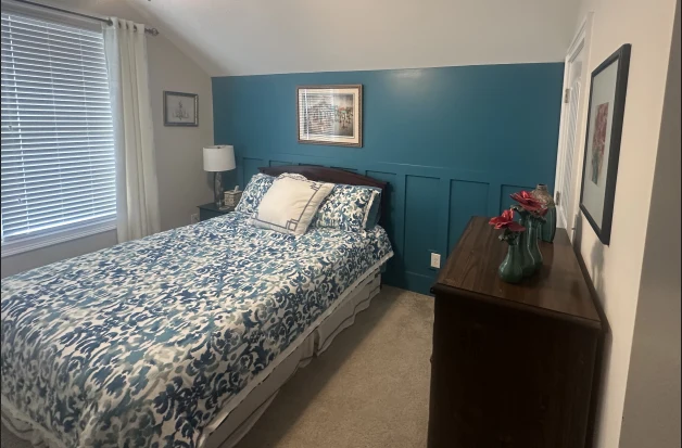 Finished blue bedroom with paneled feature wall and coordinated furnishings